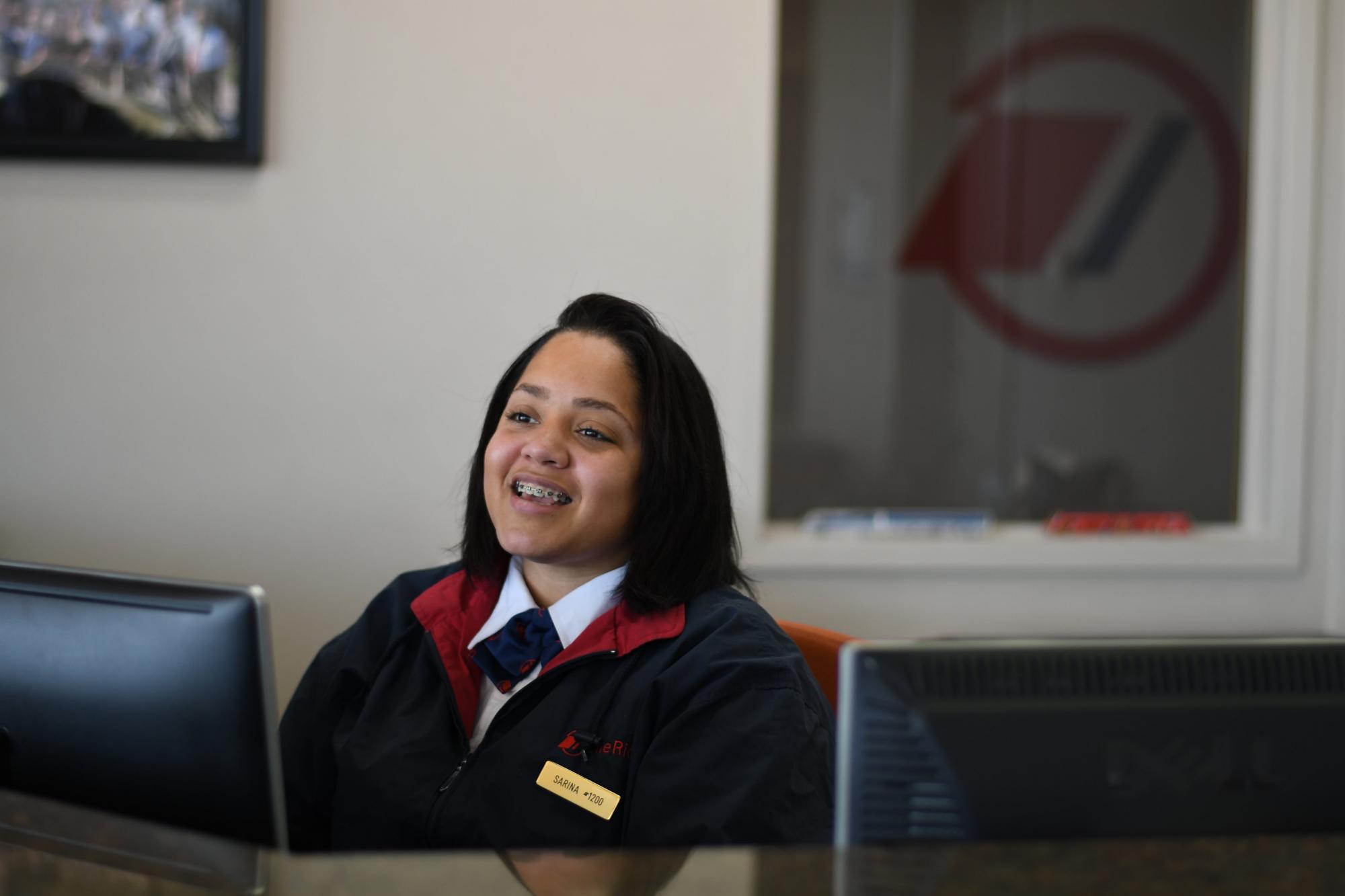 A woman smiling from her office desk.