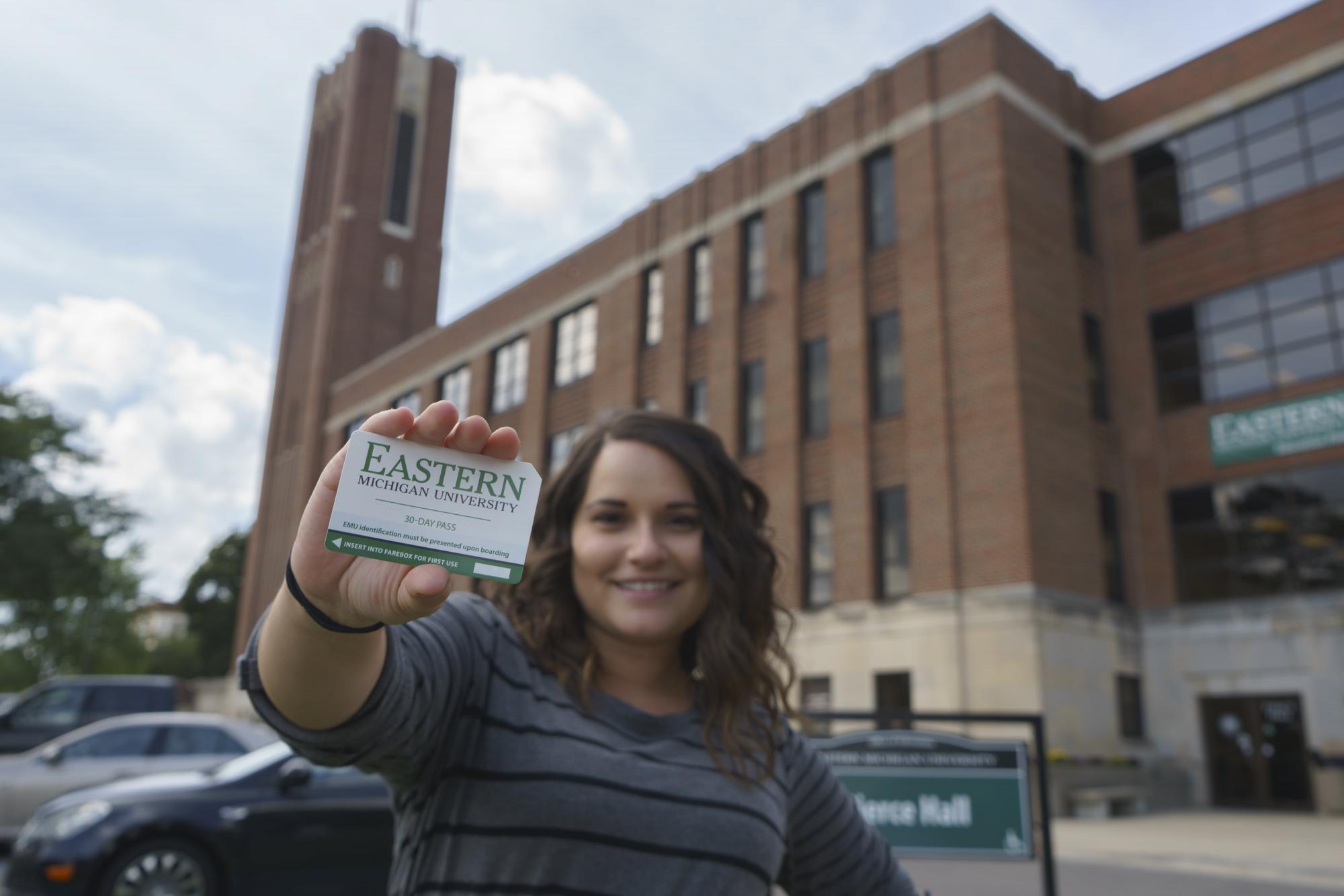 An EMU student holds up her bus pass.
