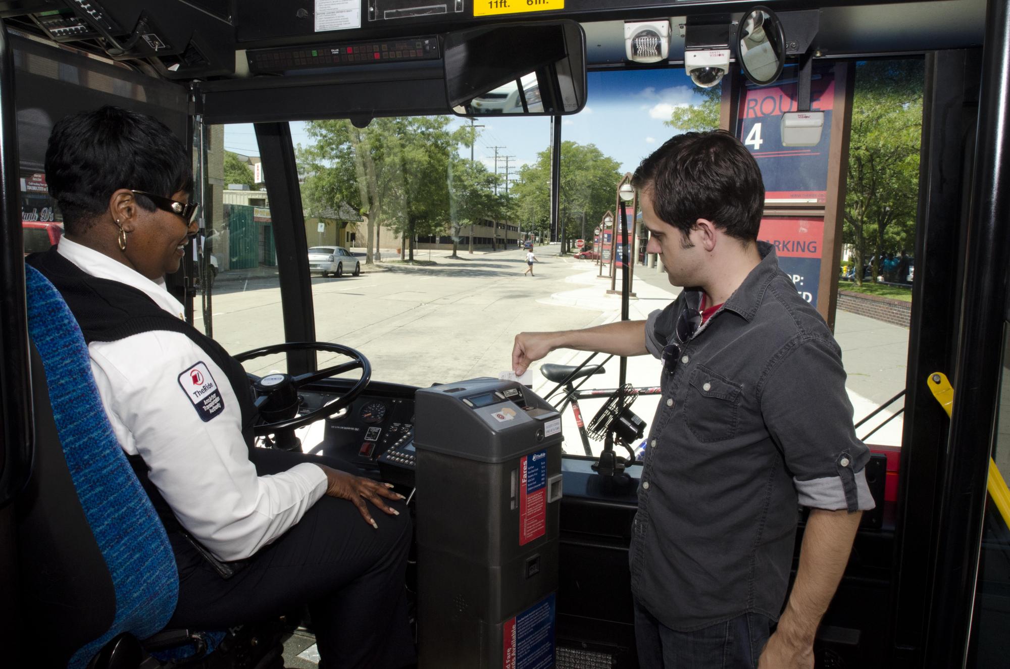 A man swipes his card as he boards the bus.