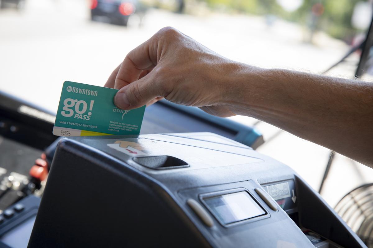 A go!pass card holder swipes their card into the fare box as they board.