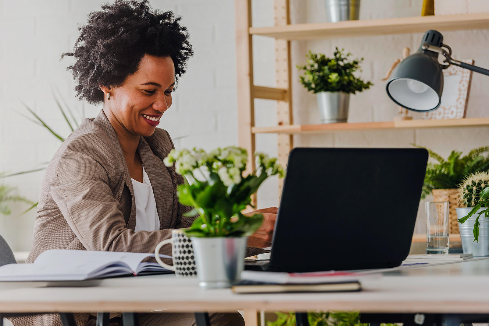 Woman at home office looking at laptop computer screen