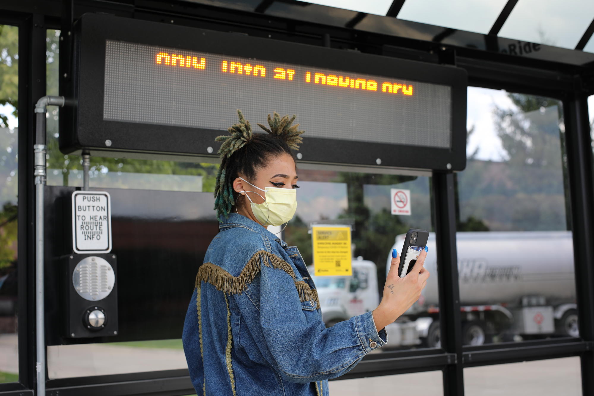 Woman looking at phone at bus stop