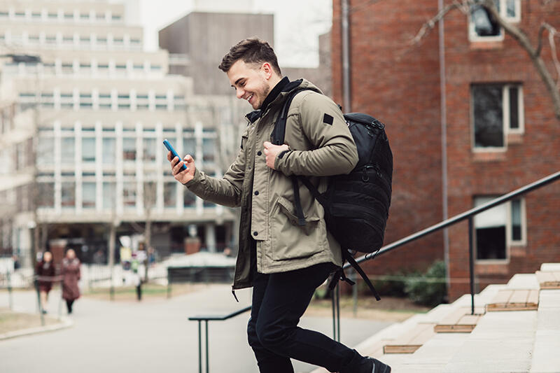 Man walking down steps looking at phone