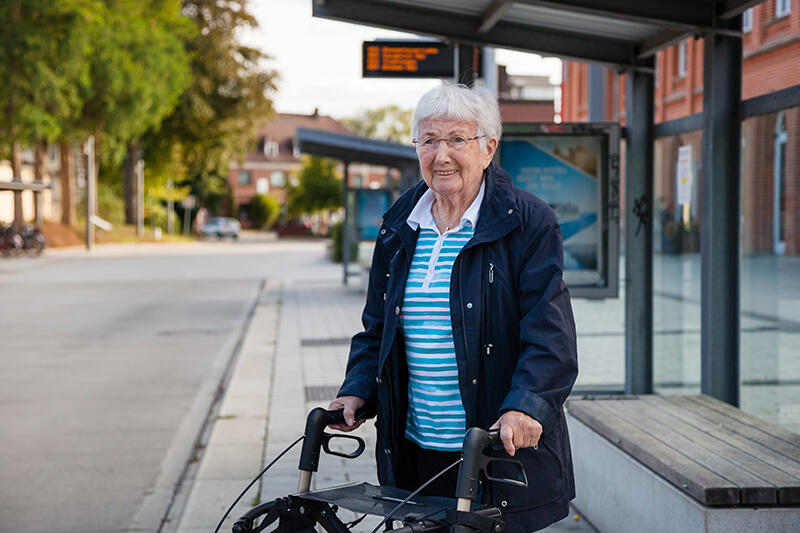 Elder woman waiting at bus shelter