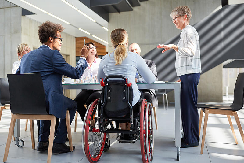 Group meeting in office building, woman in wheelchair