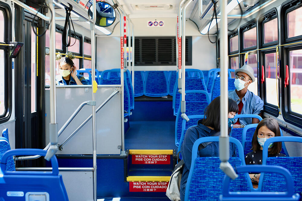 bus riders in masks riding the bus