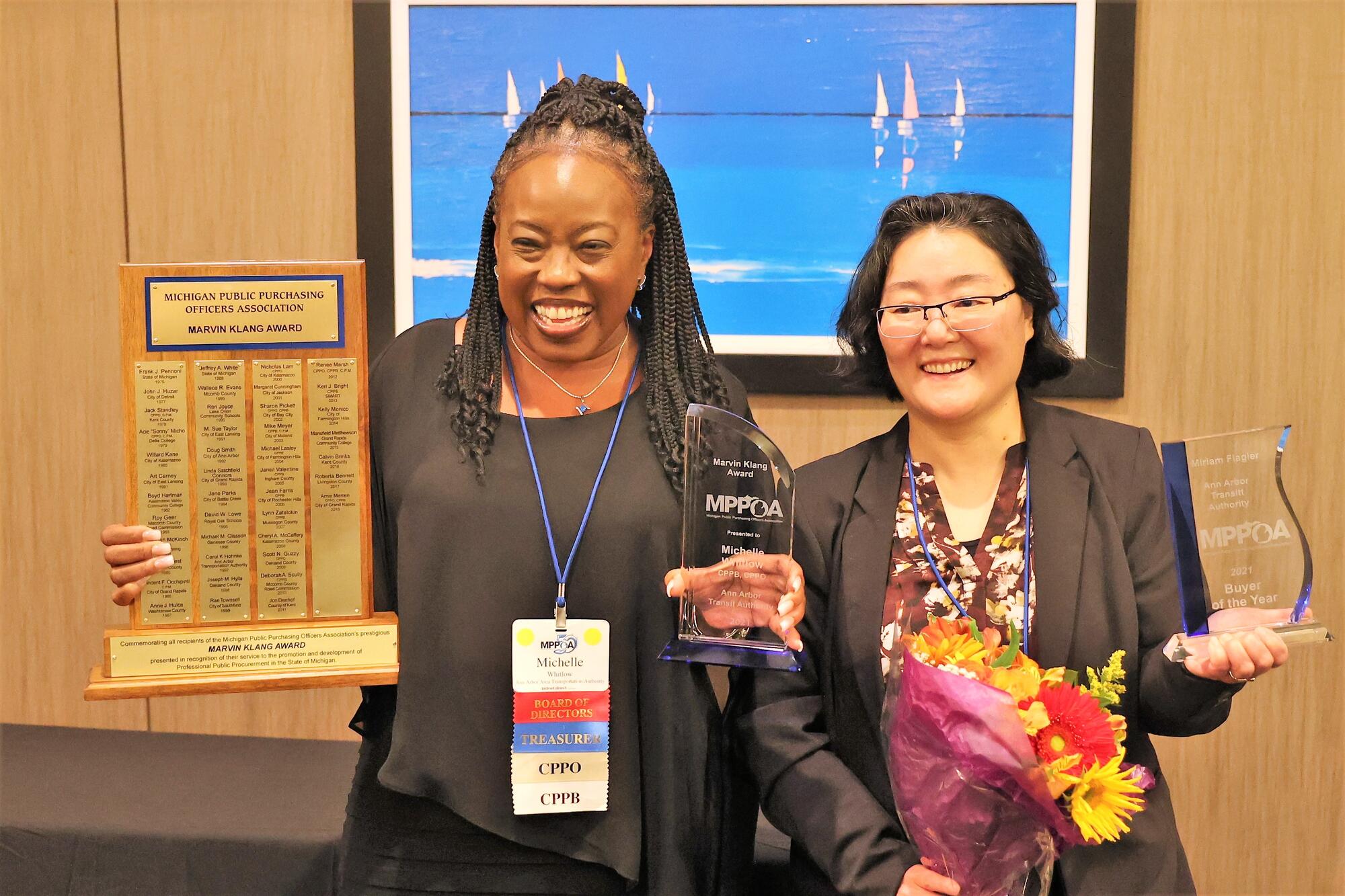 Two women standing with awards.