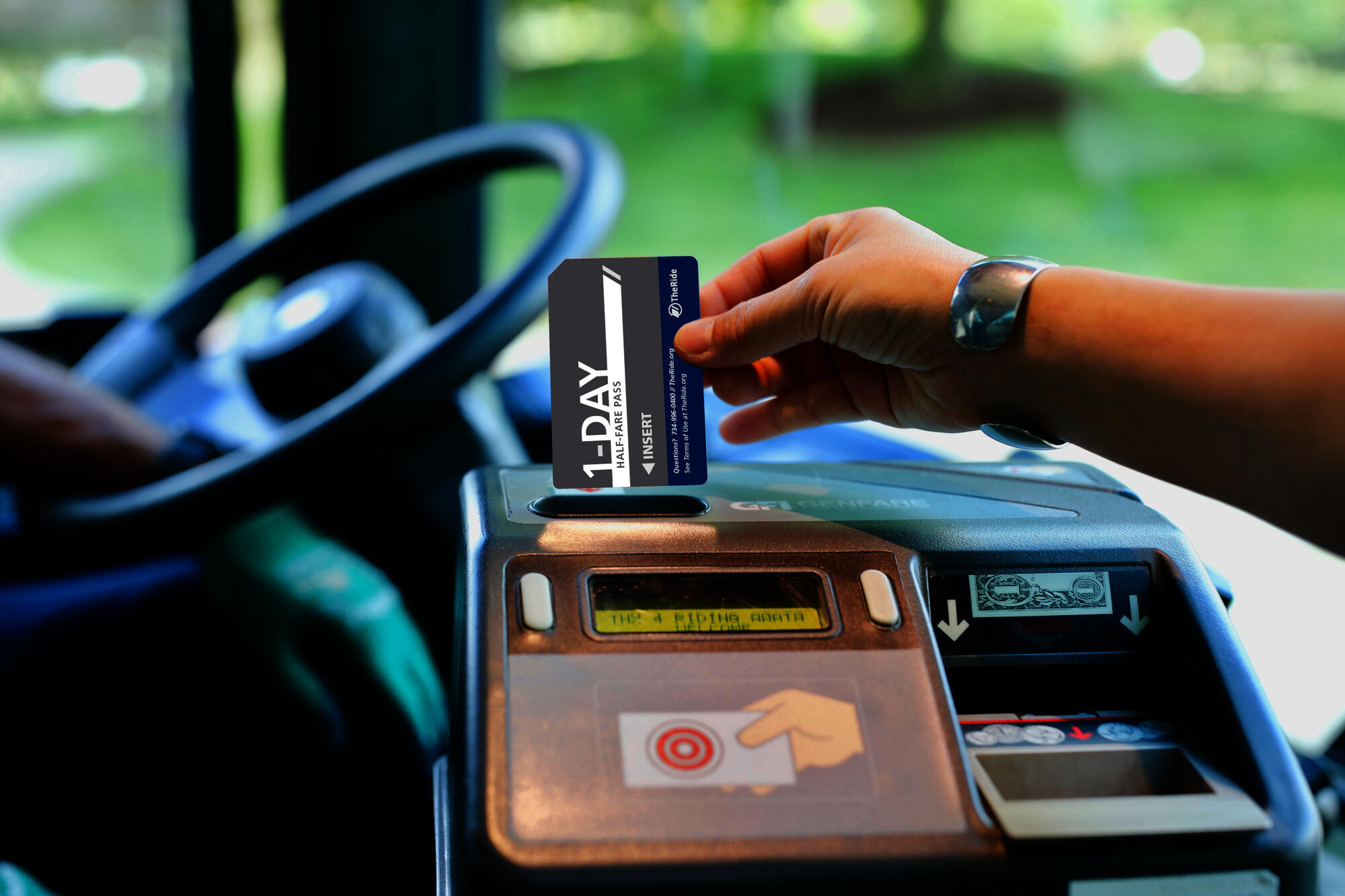 person putting pass into fare box