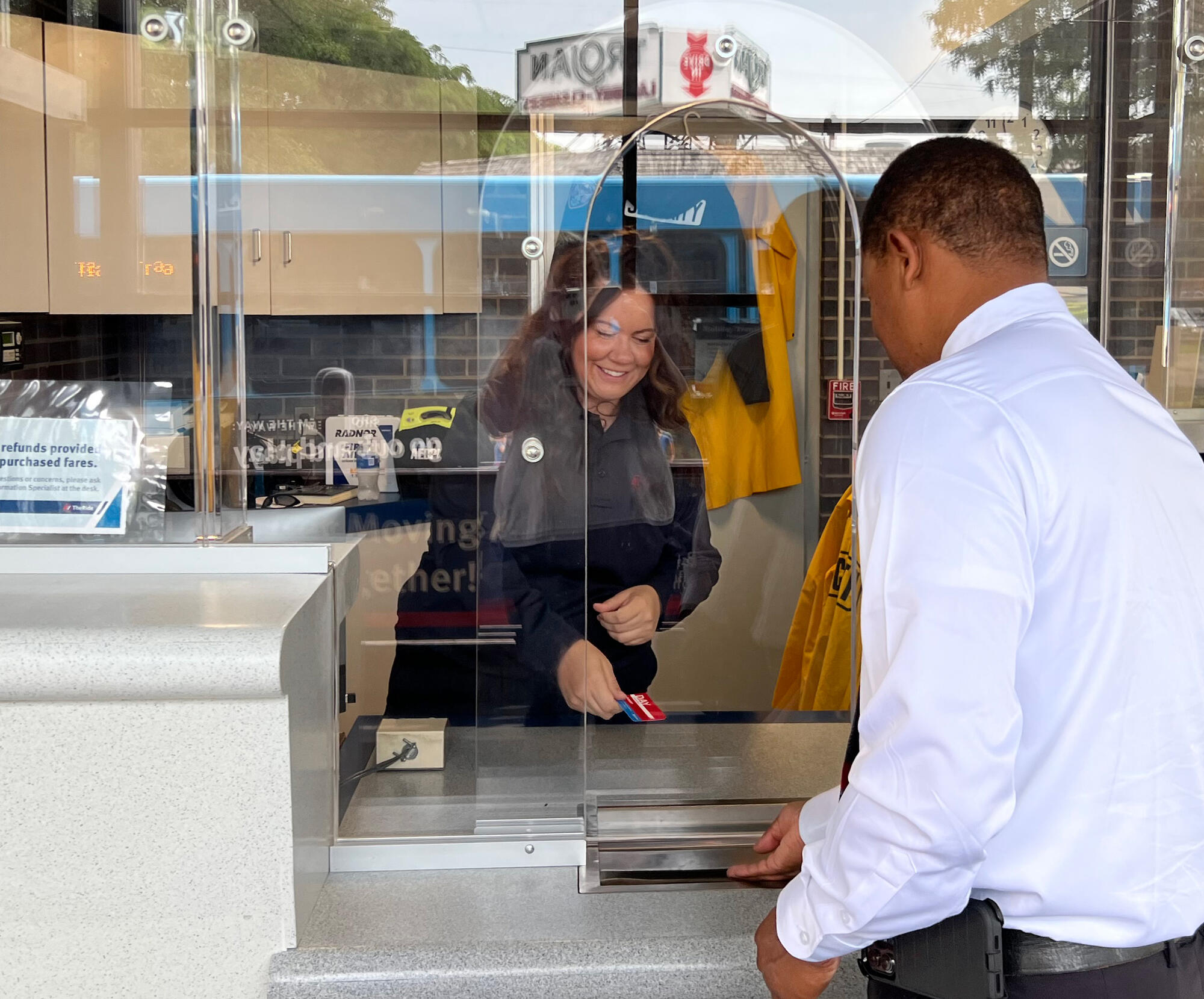 Information Specialist selling pass to customer at Ypsilanti Transit Center