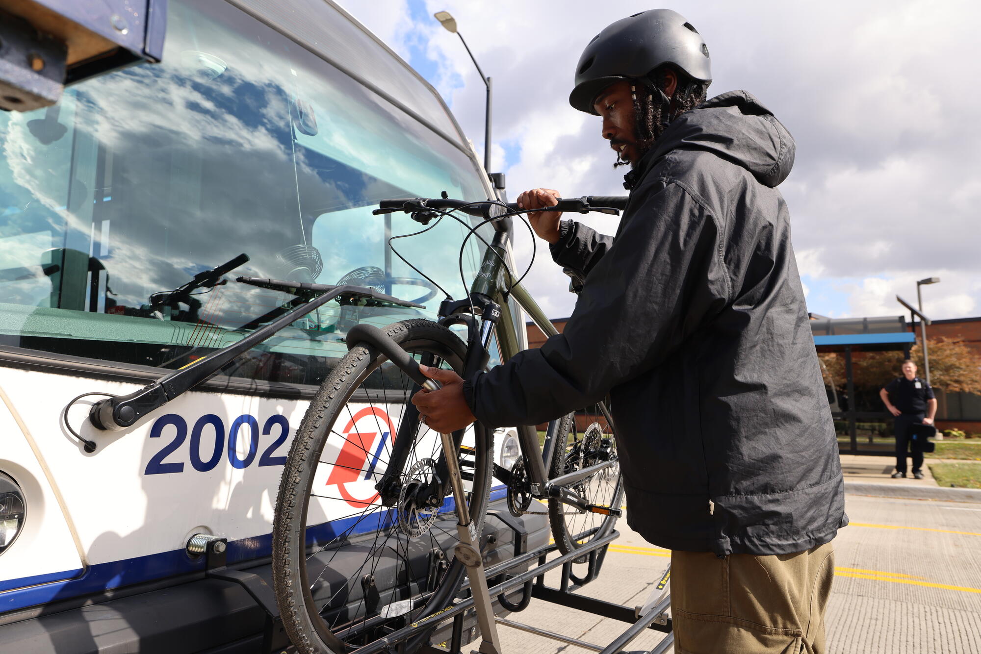 Image - Person in coat loading bike on bus