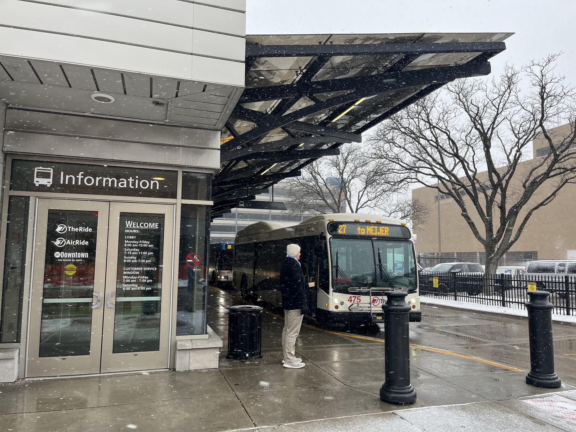 Man waiting outside the Blake Transit Center, bus in the background