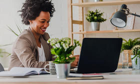 Woman at home office looking at laptop computer screen