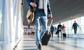 Man walking with carry on suitcase at airport