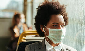 Woman on bus, wearing mask.