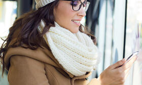 Woman in winter clothing looking at phone