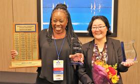 Two women standing with awards.