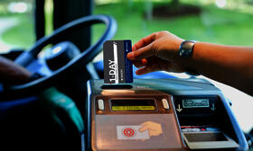 person putting pass into fare box