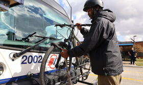 Image - Person in coat loading bike on bus