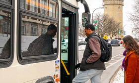 Photo of 2 riders boarding a bus in Ypsilanti in winter